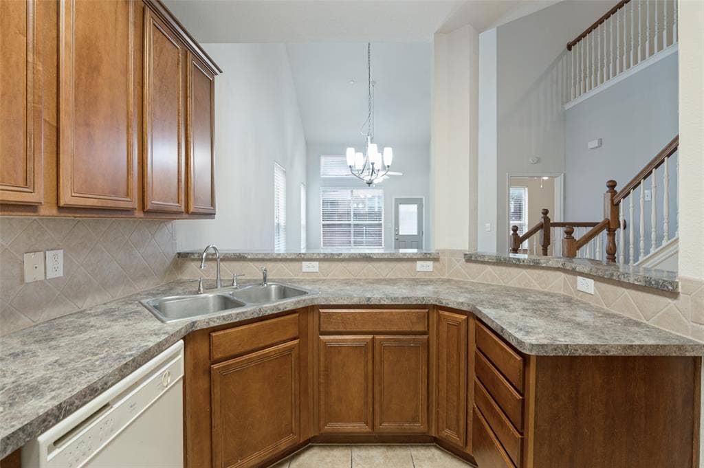 3236 Twist Trail, Plano, TX 75093 Kitchen featuring a double basin sink, ample wood cabinetry, tile backsplash, and durable countertops