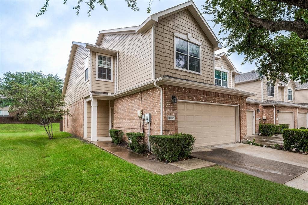 3236 Twist Trail, Plano, TX 75093 Brick and siding exterior with shake accents, featuring an attached garage, covered entry, and landscaped shrubbery