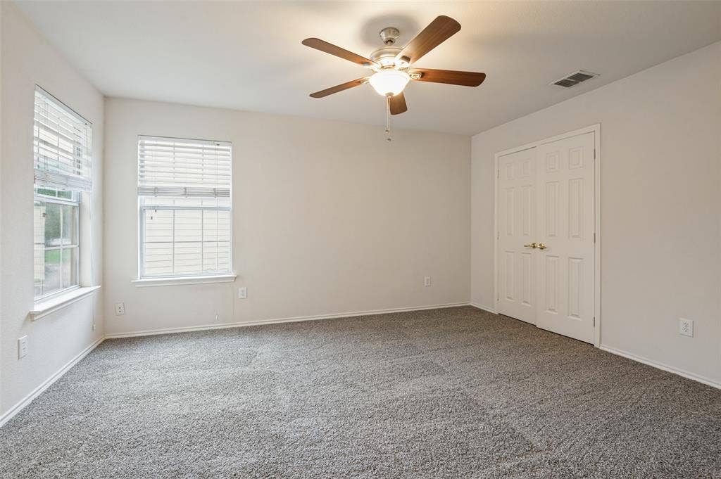 3236 Twist Trail, Plano, TX 75093 Carpeted room with a ceiling fan, two windows with blinds, and white paneled bi-fold doors
