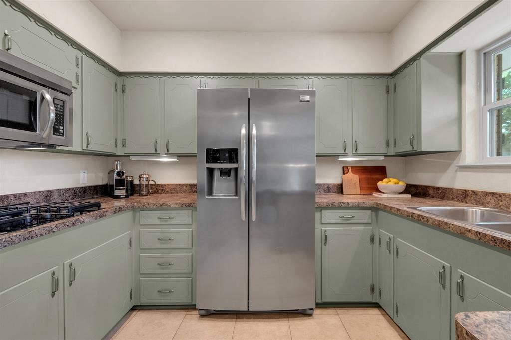 1815 Oates Drive, Dallas, TX 75228 Spacious kitchen featuring sage green cabinetry, a stainless steel side-by-side refrigerator, a built-in microwave, and a double basin stainless steel sink