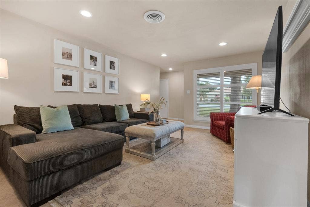1815 Oates Drive, Dallas, TX 75228 Spacious living area featuring neutral wall tones, recessed lighting, and a large window with horizontal blinds