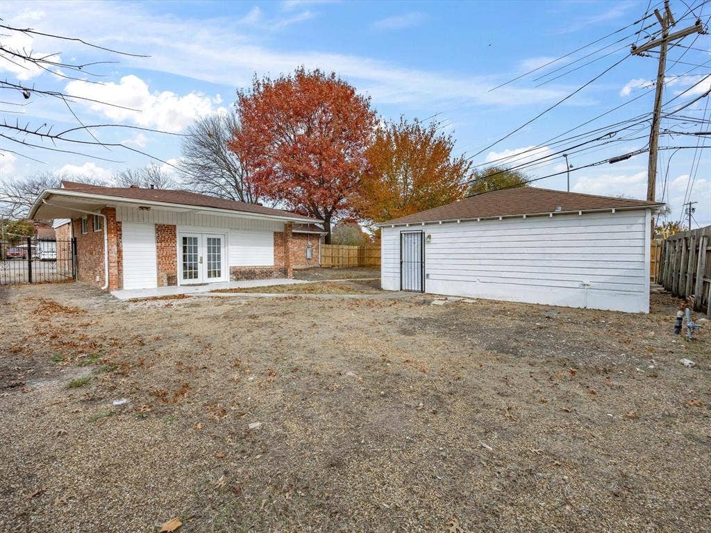 10270 Kilkenny Place, Dallas, TX 75228 Detached structure with white siding and a brown roof, featuring a security screen door and a fenced perimeter