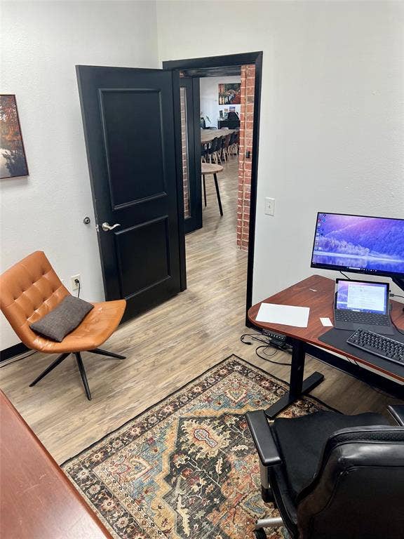123 W Princeton Drive, #200, Princeton, TX 75407 Wood-finish flooring with white walls and black interior doors