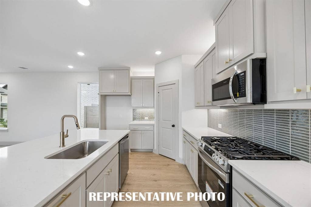 Beautiful cabinetry, gorgeous countertops and a stylish backsplash effortlessly blend with contemporary stainless steel to create a kitchen for the ages!  REPRESENTATIVE PHOTO