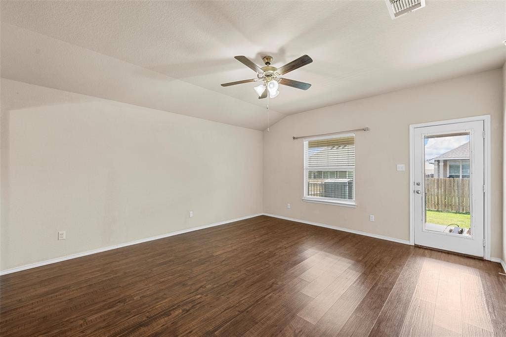 3217 Beutel Road, Lorena, TX 76655 Empty room featuring dark wood finished floors, ceiling fan, and vaulted ceiling