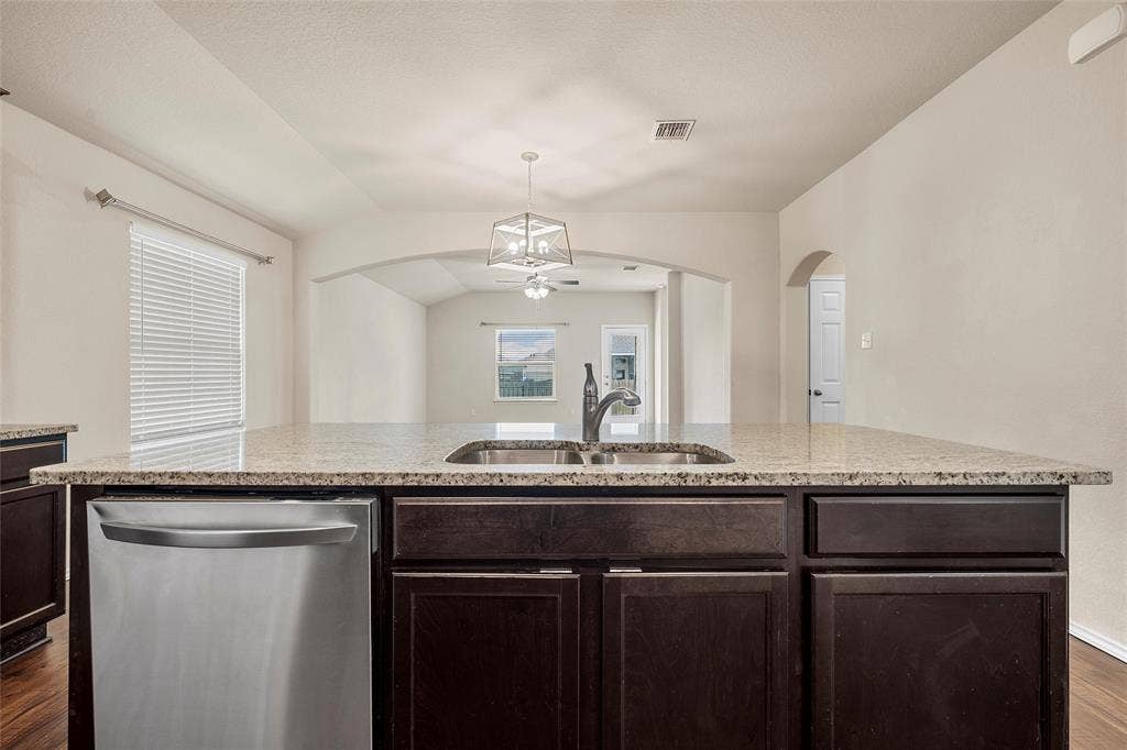 3217 Beutel Road, Lorena, TX 76655 Kitchen featuring dishwasher, ceiling fan, dark wood-style floors, arched walkways, and dark brown cabinetry