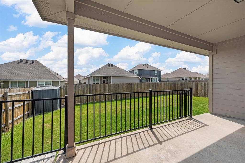 3217 Beutel Road, Lorena, TX 76655 Fenced backyard featuring a residential view, a storage unit, and a patio area