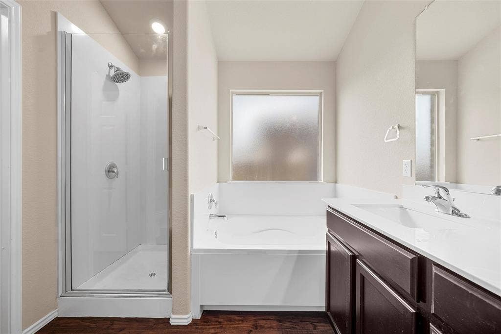 3217 Beutel Road, Lorena, TX 76655 Full bathroom with a shower stall, a garden tub, vanity, and wood finished floors