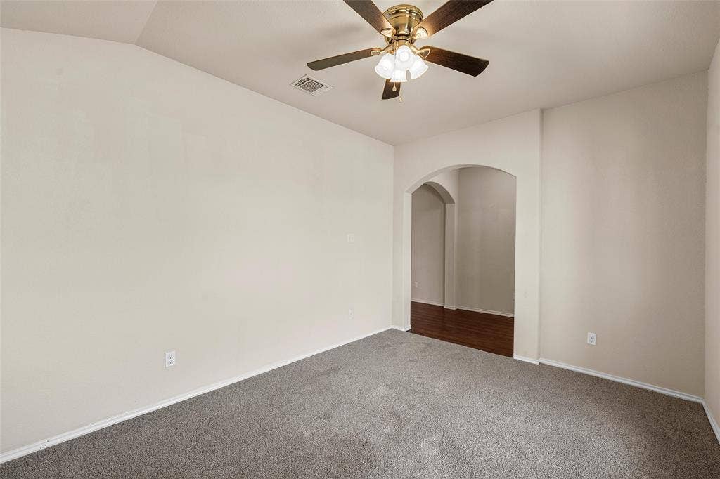 3217 Beutel Road, Lorena, TX 76655 Unfurnished room with dark colored carpet, arched walkways, and a ceiling fan