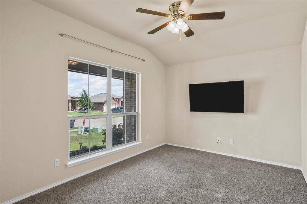 3217 Beutel Road, Lorena, TX 76655 Unfurnished room with vaulted ceiling, carpet floors, and ceiling fan