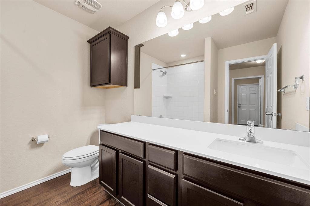 3217 Beutel Road, Lorena, TX 76655 Bathroom with vanity, tiled shower, and wood finished floors