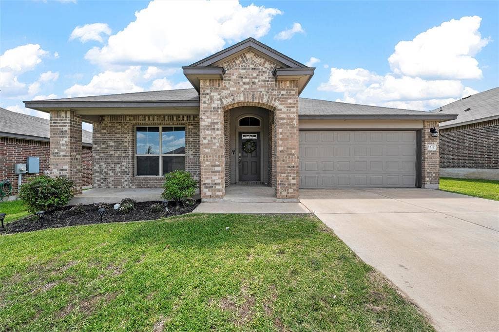 3217 Beutel Road, Lorena, TX 76655 View of front facade featuring brick siding, an attached garage, and driveway