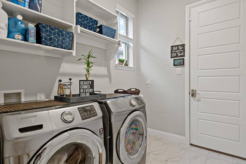 Dedicated laundry area featuring white wall shelving, a window with blinds, and white panel doors