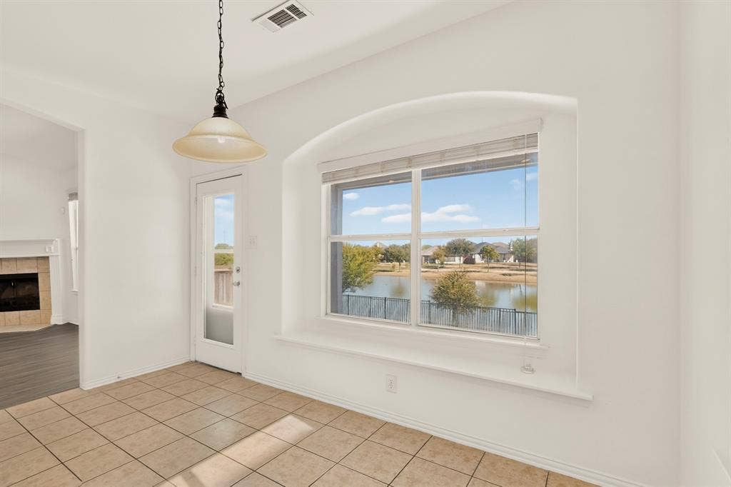 14908 Riverside Drive, Little Elm, TX 75068 Arched window with water scenery, tile flooring, glass-paneled door, and a pendant light fixture