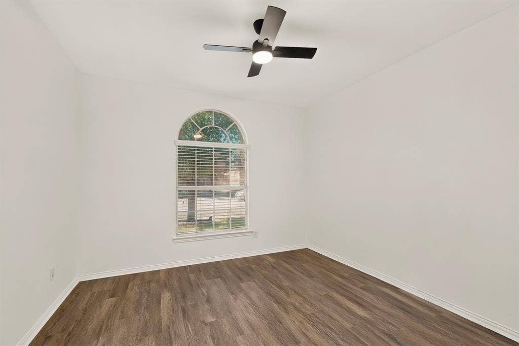 14908 Riverside Drive, Little Elm, TX 75068 Arched window with blinds, wood-finish flooring, and a ceiling fan with integrated lighting