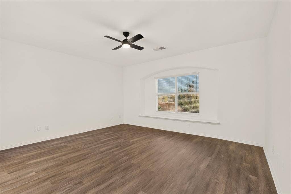 14908 Riverside Drive, Little Elm, TX 75068 Wood-finish flooring, white walls, and a window with an arched architectural detail