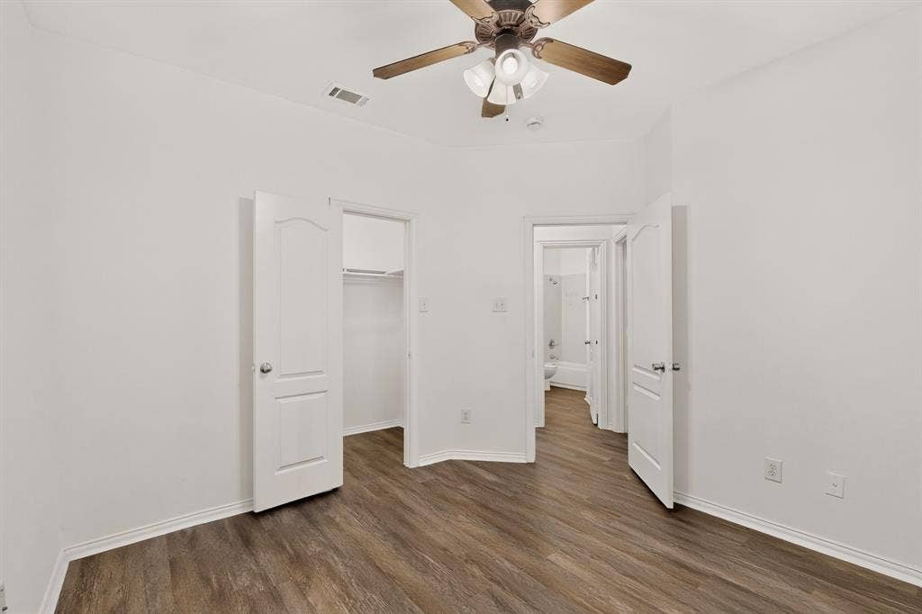 14908 Riverside Drive, Little Elm, TX 75068 Wood-finish flooring with white baseboards, white walls, and a ceiling fan with integrated lighting