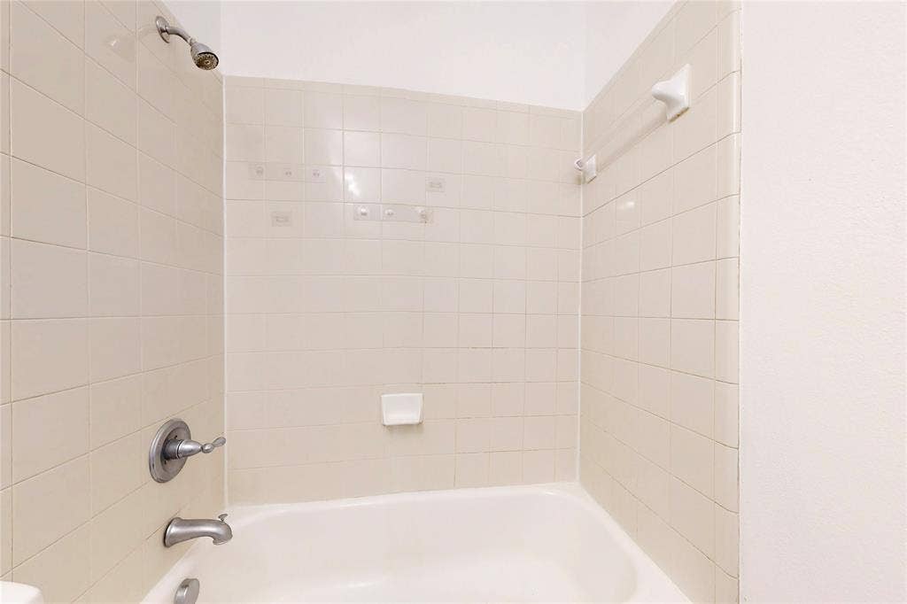 14908 Riverside Drive, Little Elm, TX 75068 Bathtub with subway tile surround, chrome showerhead, and matching chrome fixtures