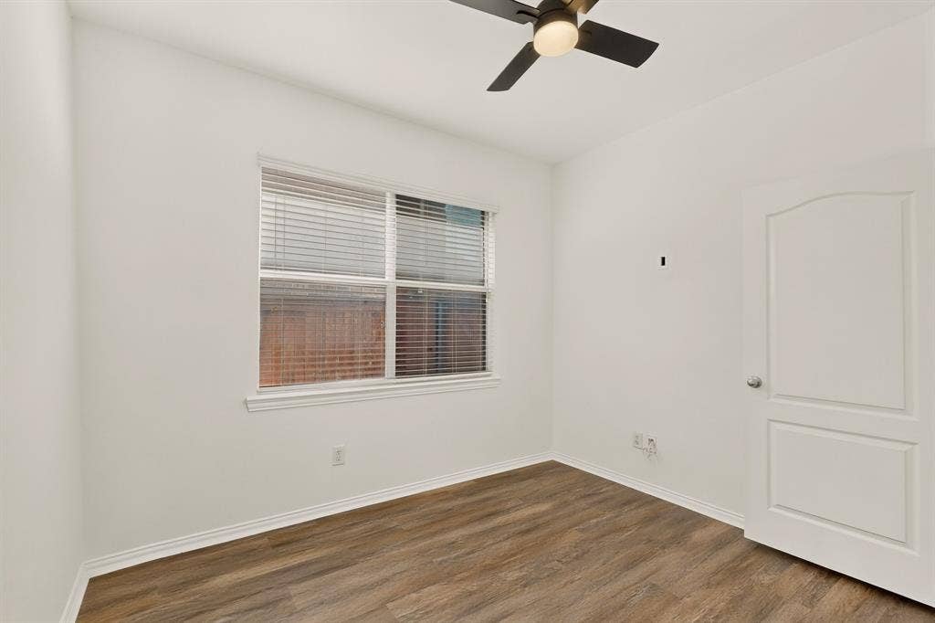 14908 Riverside Drive, Little Elm, TX 75068 Wood-finish flooring, white walls, and a window with blinds