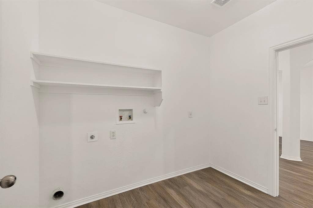 14908 Riverside Drive, Little Elm, TX 75068 Laundry space featuring built-in shelving, wood-finish flooring, and crisp white walls