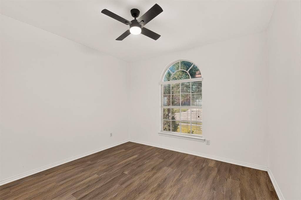 14908 Riverside Drive, Little Elm, TX 75068 Arch-top window with blinds, wood-finish flooring, white walls, and a ceiling fan with integrated lighting