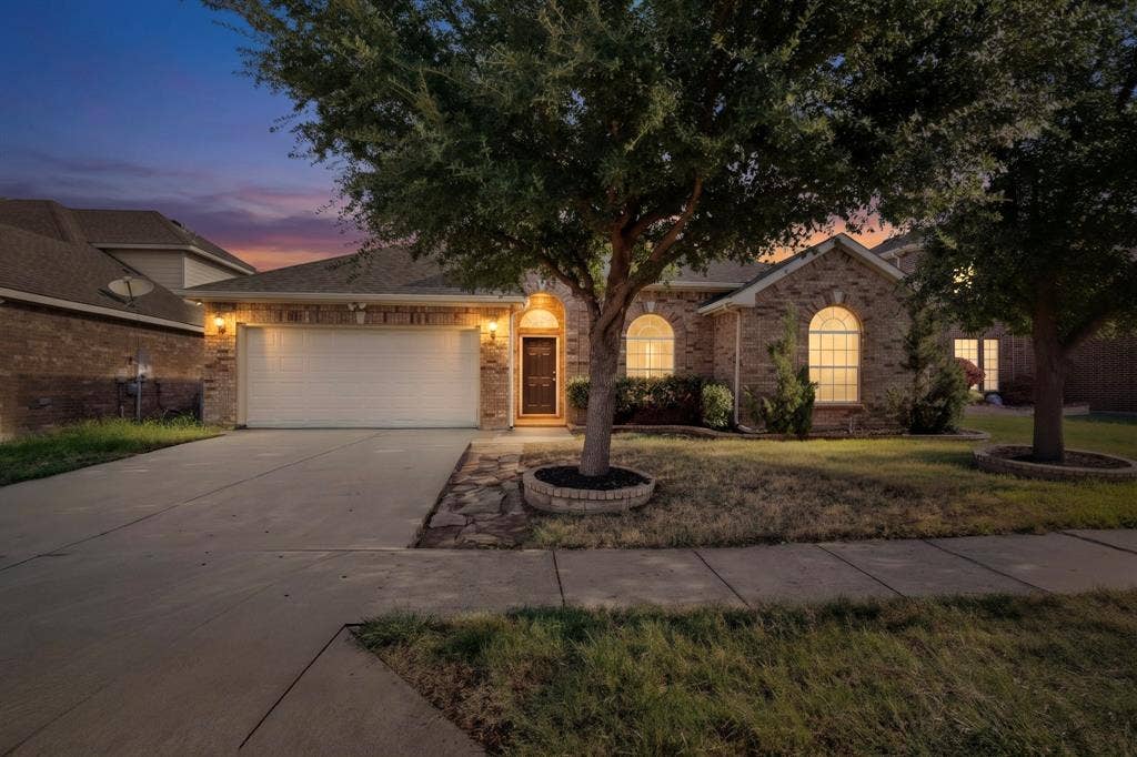 14908 Riverside Drive, Little Elm, TX 75068 Brick facade residence with an attached garage and concrete driveway