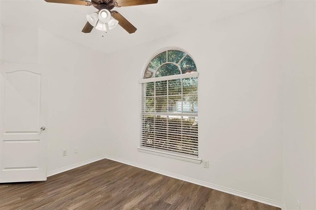 14908 Riverside Drive, Little Elm, TX 75068 Arched window with blinds, wood-finish flooring, ceiling fan, and white interior paint