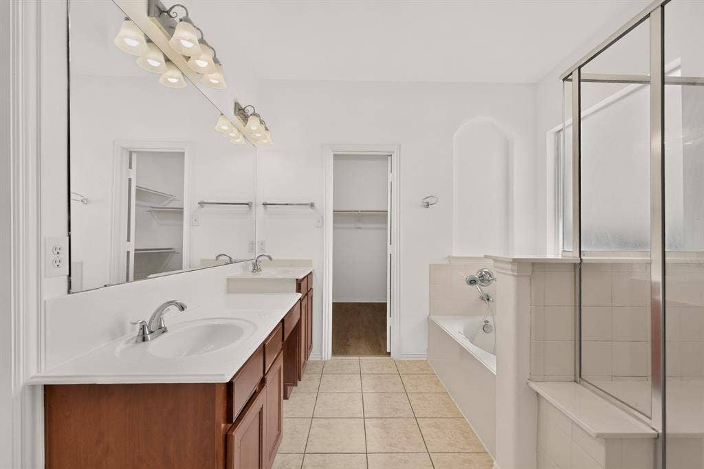 14908 Riverside Drive, Little Elm, TX 75068 Dual vanity with integrated sinks, a built-in tub, a glass-enclosed shower, and tile flooring