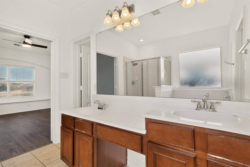 14908 Riverside Drive, Little Elm, TX 75068 Dual vanity with integrated sinks, wood-finish cabinetry, and chrome fixtures