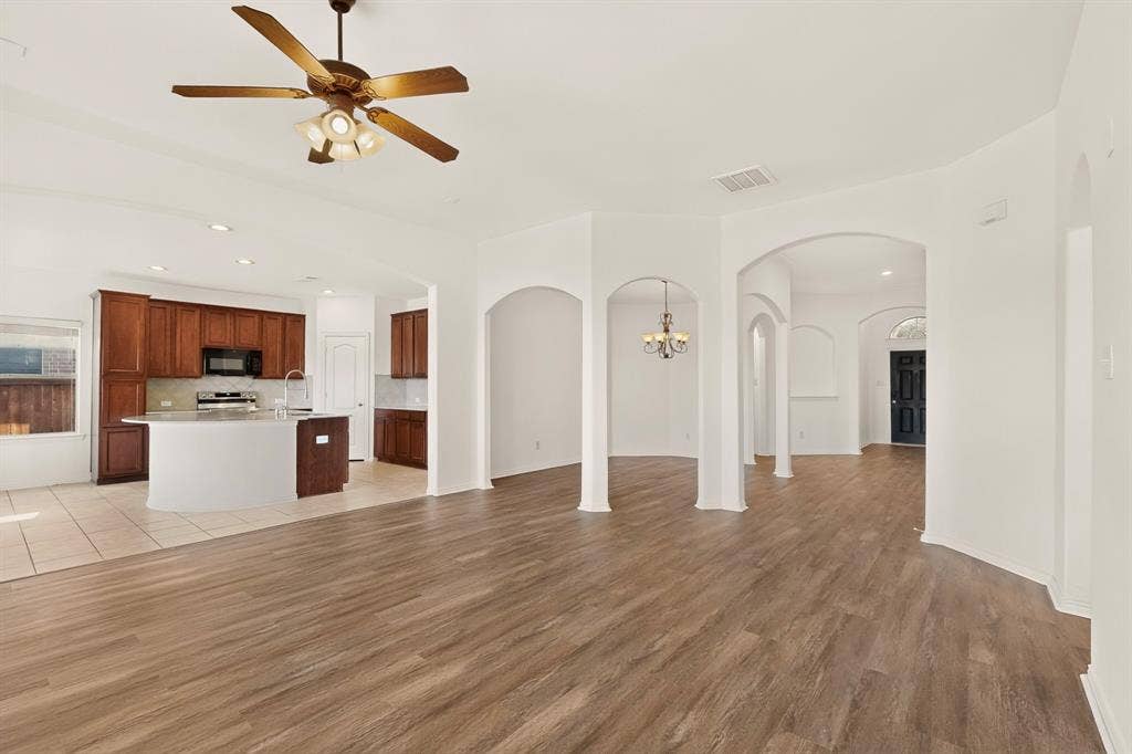 14908 Riverside Drive, Little Elm, TX 75068 Open-concept living area with wood-finish flooring, recessed lighting, and architectural archways