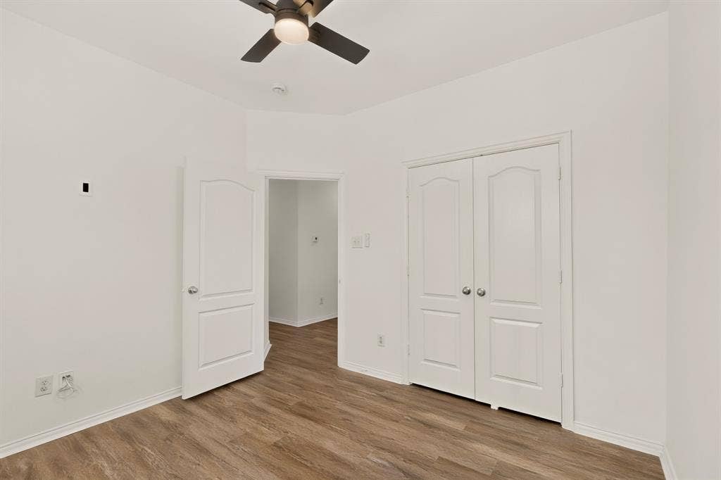 14908 Riverside Drive, Little Elm, TX 75068 Wood-finish flooring, white paneled doors, ceiling fan with integrated lighting, and white walls