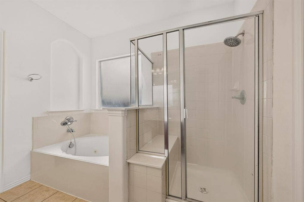 14908 Riverside Drive, Little Elm, TX 75068 Glass-enclosed shower, jetted soaking tub, tiled shower walls, chrome fixtures, and privacy window