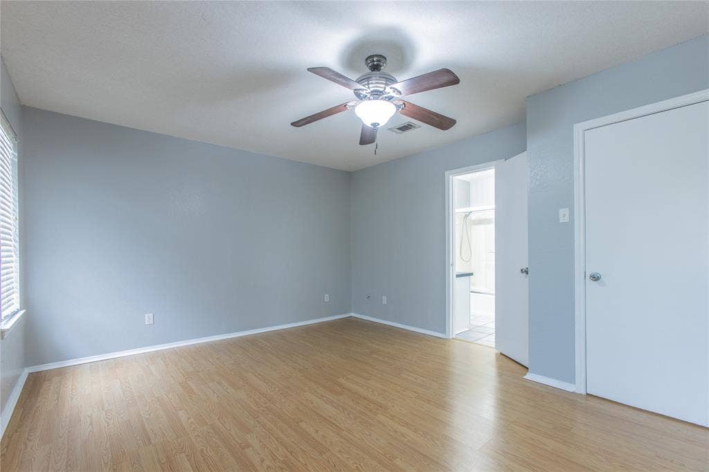 2308 Melissa Drive, #H5, Waco, TX 76708 Wood-finish flooring, ceiling fan with integrated lighting, window with horizontal blinds, white interior doors, and pale blue wall finish