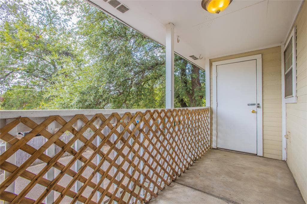 2308 Melissa Drive, #H5, Waco, TX 76708 Covered porch with concrete flooring, wood lattice railing, white support columns, and an overhead light fixture