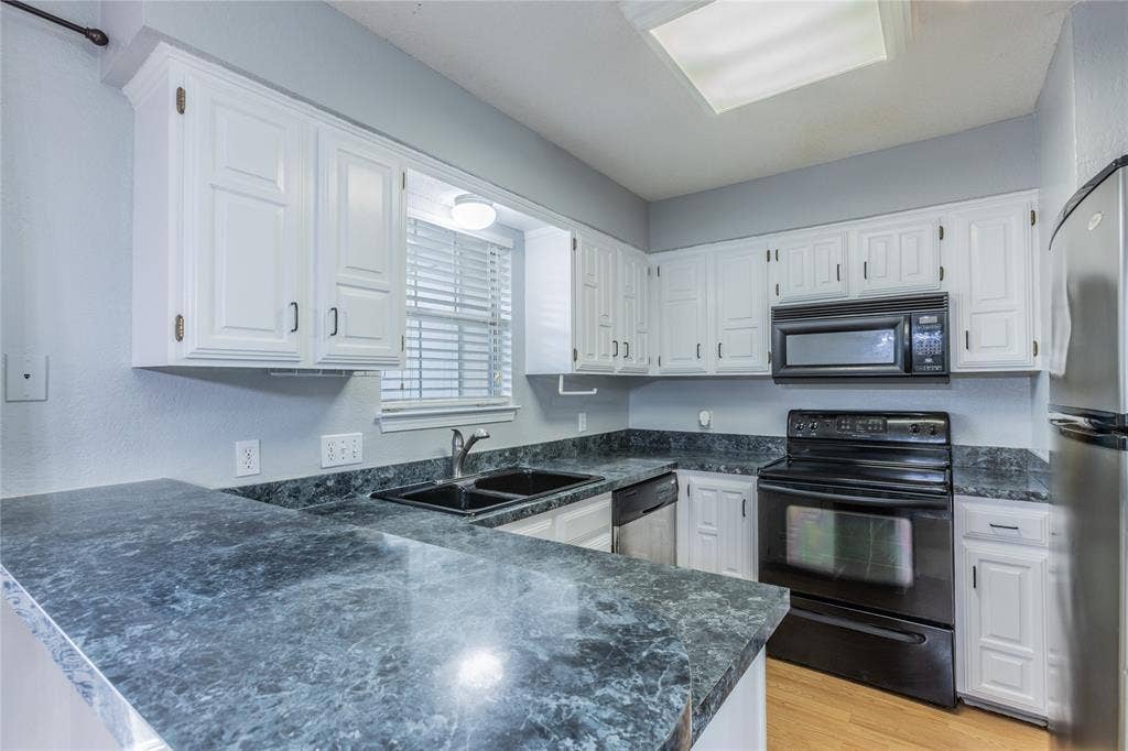 2308 Melissa Drive, #H5, Waco, TX 76708 White cabinetry, gray countertops, built-in microwave, black electric range, and wood-finish flooring