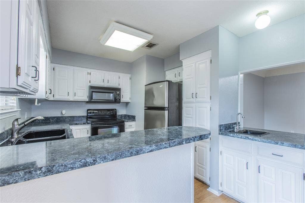 2308 Melissa Drive, #H5, Waco, TX 76708 Kitchen featuring white cabinetry, dark countertops, a stainless steel refrigerator, and built-in microwave