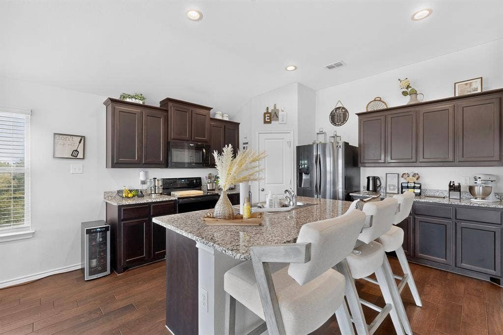 11700 Aldermoor Court, Fort Worth, TX 76036 Kitchen featuring dark wood cabinetry, granite countertops, wood-finish flooring, a stainless steel refrigerator, and recessed lighting