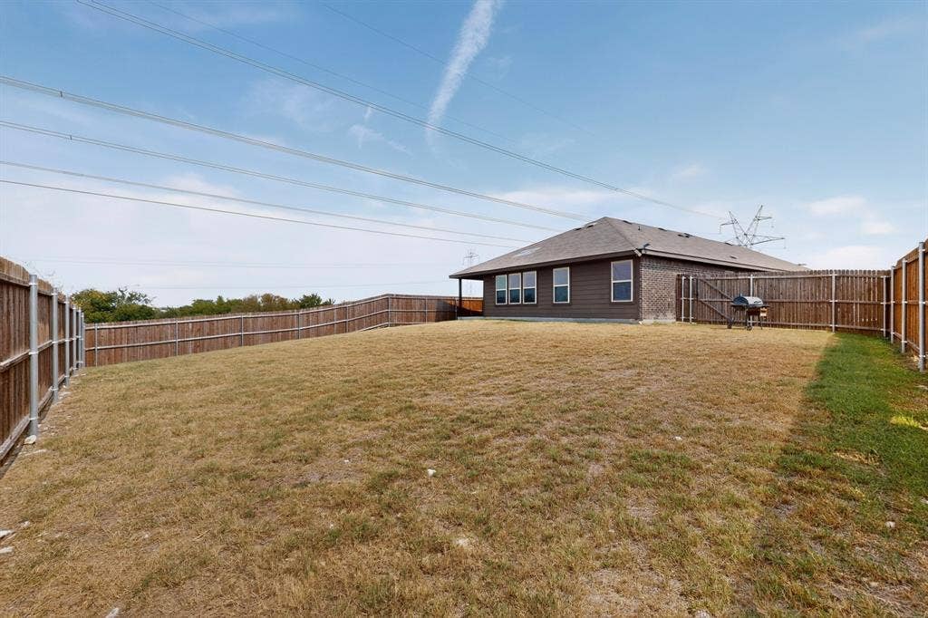 11700 Aldermoor Court, Fort Worth, TX 76036 Expansive backyard featuring wood privacy fencing, a manicured lawn, and a back patio