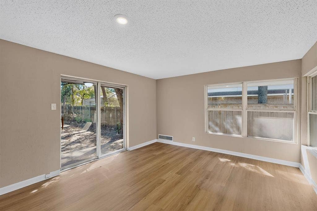 2314 Wales Place, Irving, TX 75062 Recessed lighting, wood-finish flooring, sliding glass door, multiple windows, and neutral wall tones