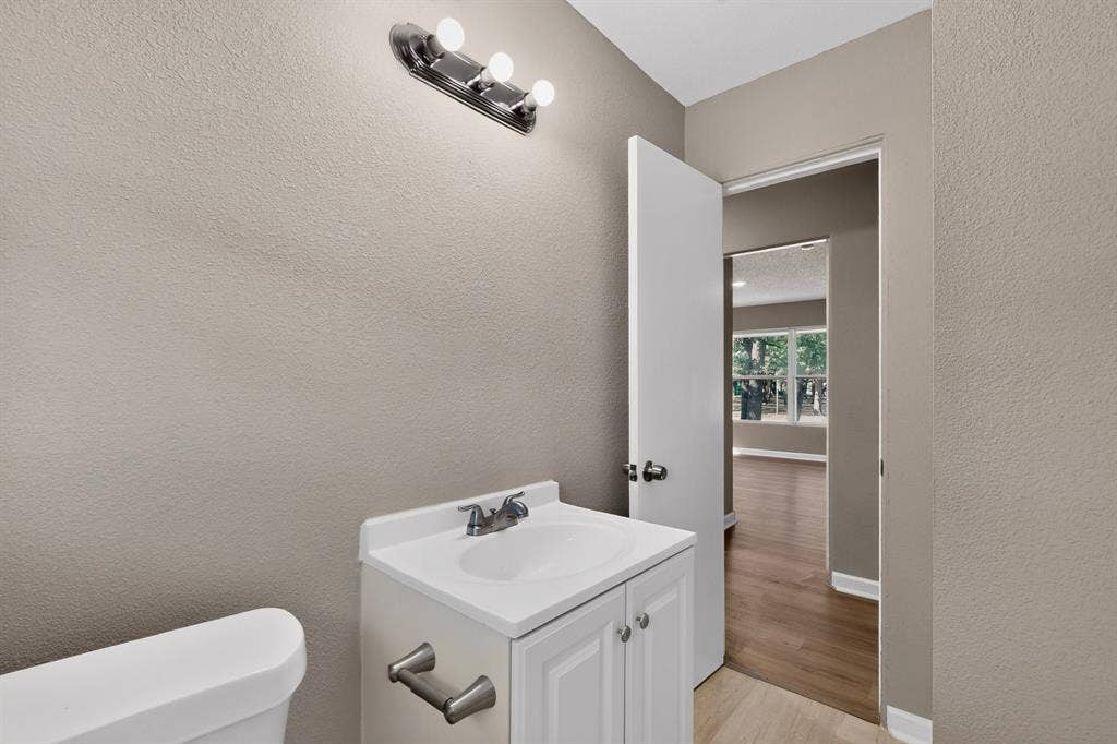 2314 Wales Place, Irving, TX 75062 White vanity with a single basin sink, chrome faucet, and brushed nickel hardware