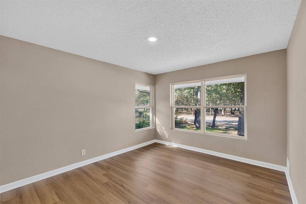 2314 Wales Place, Irving, TX 75062 Wood-finish flooring, recessed ceiling light, multiple windows, and neutral wall paint