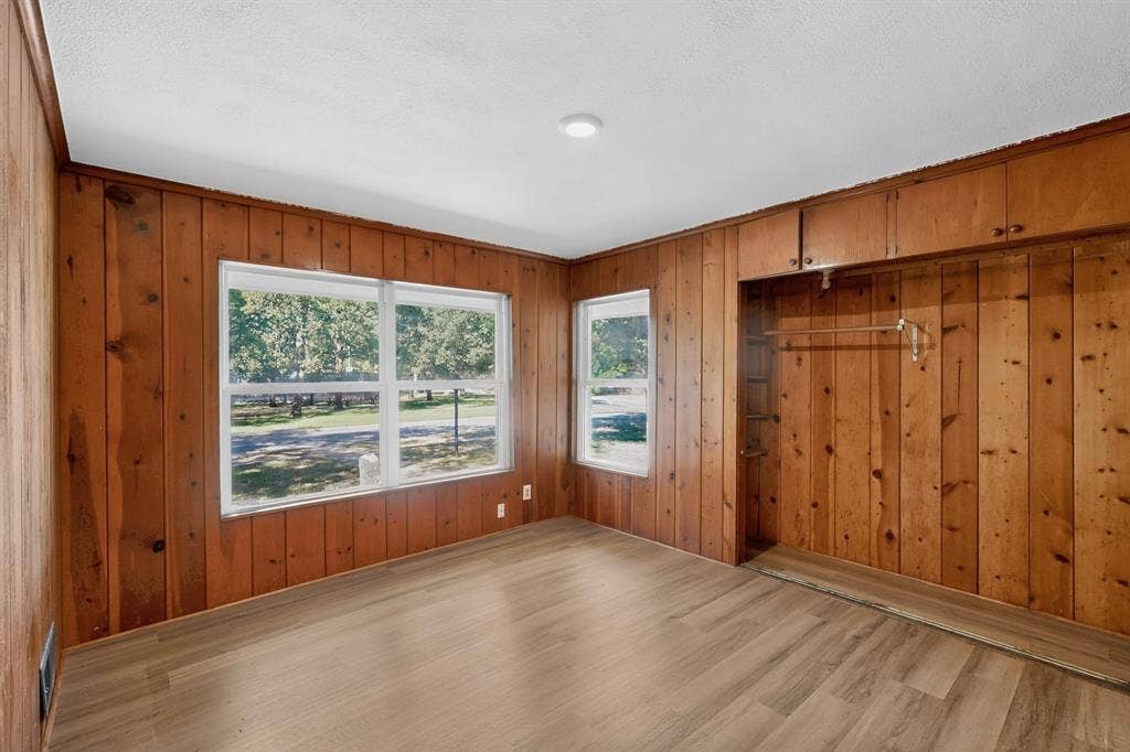 2314 Wales Place, Irving, TX 75062 Wood-finish flooring, wood panel walls, recessed lighting, multiple windows, and built-in closet storage