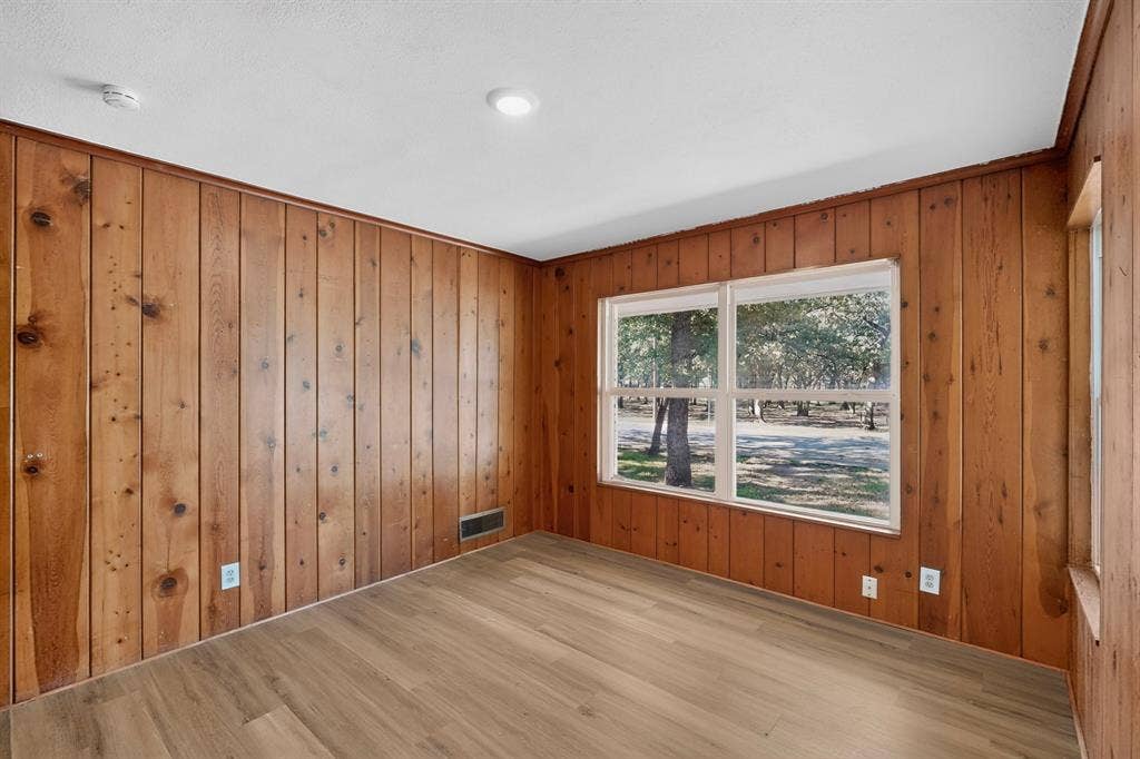 2314 Wales Place, Irving, TX 75062 Wood-finish flooring with wood paneling walls and white trim