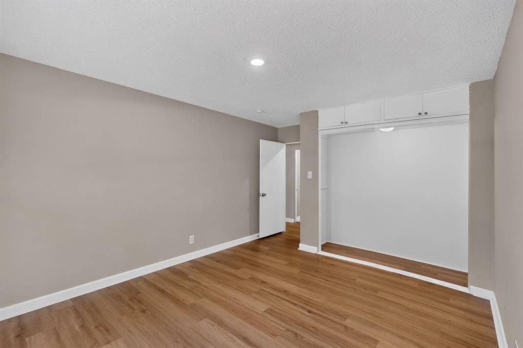 2314 Wales Place, Irving, TX 75062 Wood-finish flooring, recessed lighting, built-in overhead cabinetry, and neutral wall tones