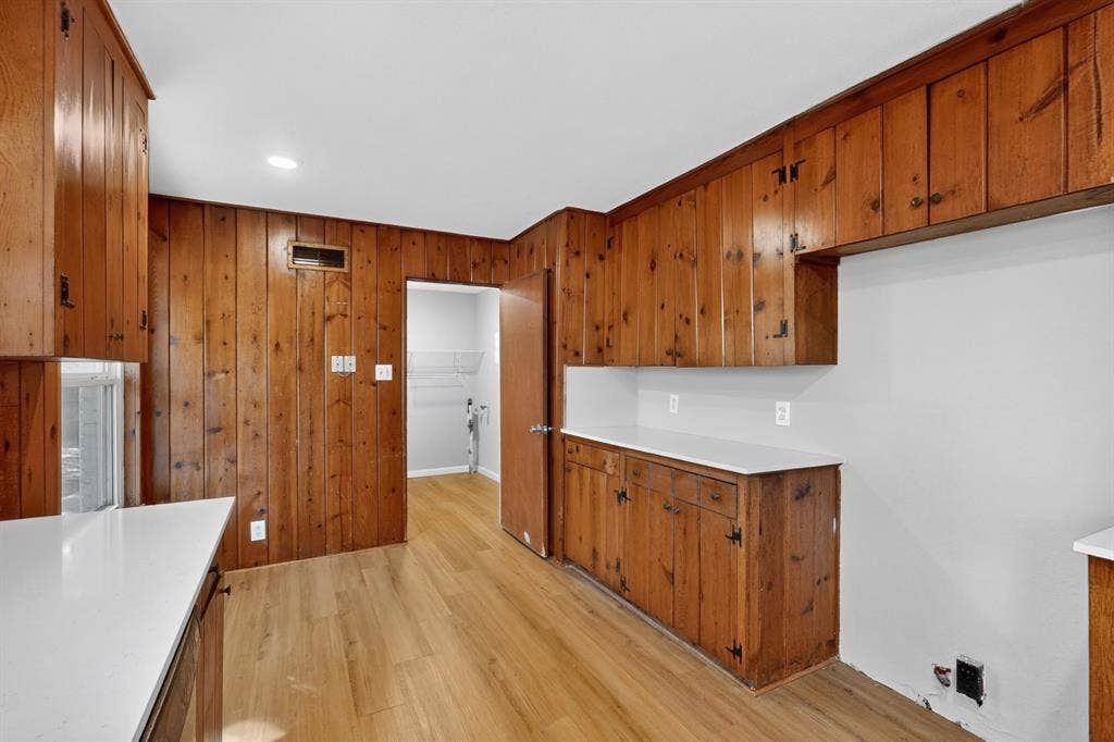 2314 Wales Place, Irving, TX 75062 Wood-paneled walls and cabinetry, white countertops, wood-finish flooring, and recessed lighting