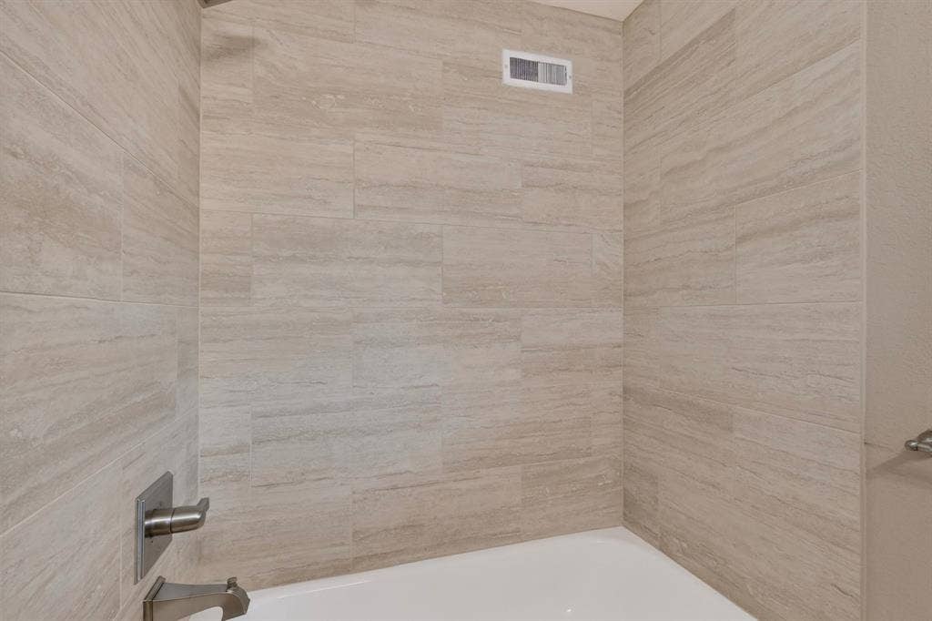 2314 Wales Place, Irving, TX 75062 Tub shower with large format tile surround and brushed nickel fixtures