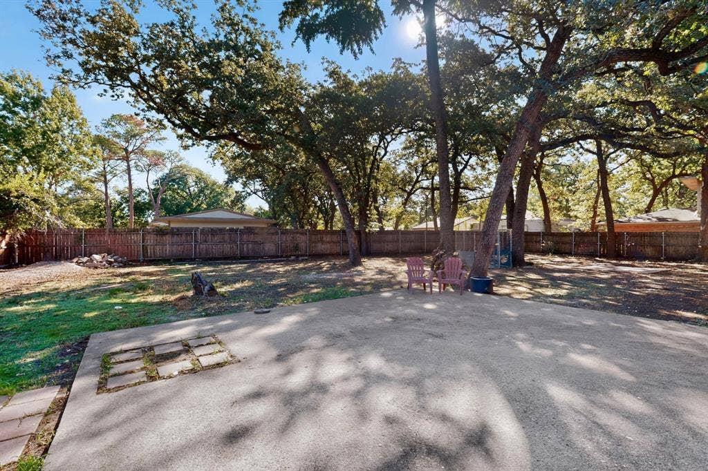 2314 Wales Place, Irving, TX 75062 Expansive concrete patio with mature trees providing natural shade