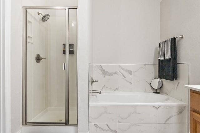 7944 Eddie Drive, Plano, TX 75025 Walk-in shower with clear glass enclosure, a built-in shower caddy, and a polished chrome shower head