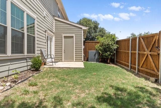 7944 Eddie Drive, Plano, TX 75025 Backyard space featuring a wooden fence, a small paved patio, and a side door entry