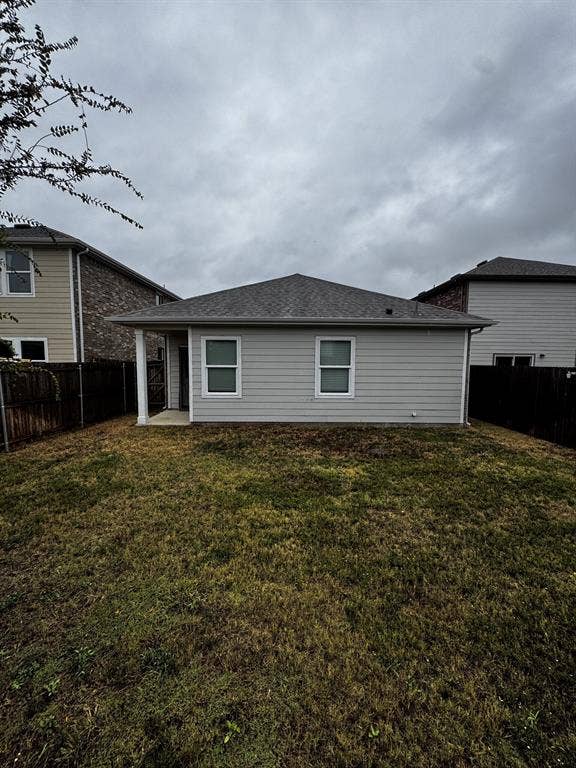 1813 Chapel Hill Road, Princeton, TX 75407 Rear elevation featuring light gray siding, a covered patio, and a shingle roof